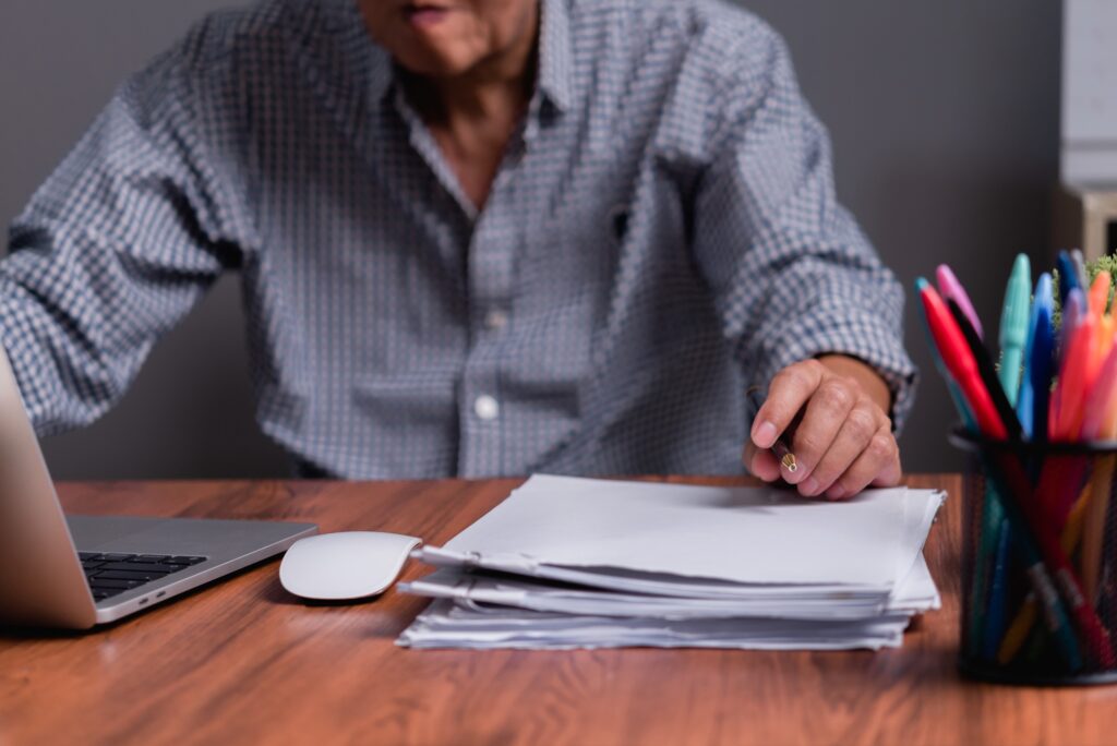 Asian senior businessman checking work papers and business reports